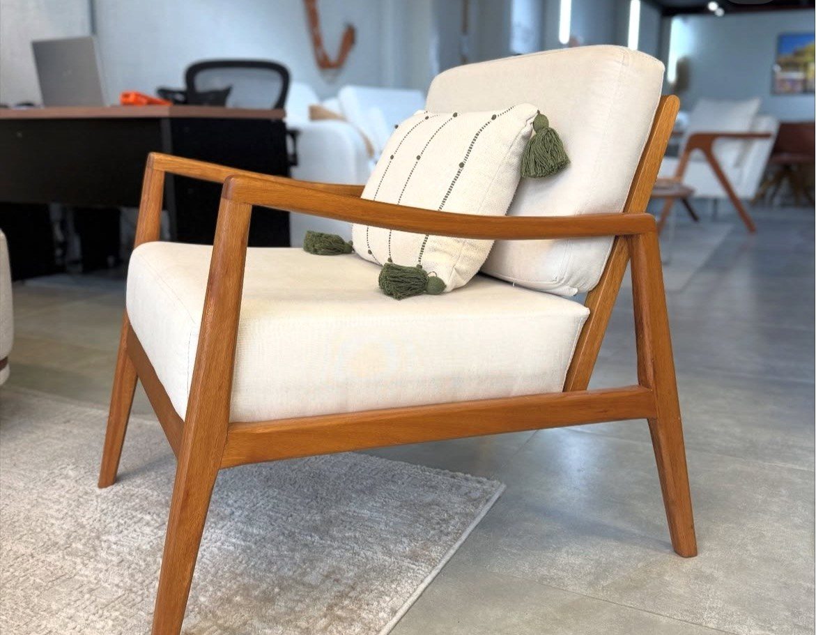 Poltrona em madeira maciça com estofado off-white e almofada com pompons verdes