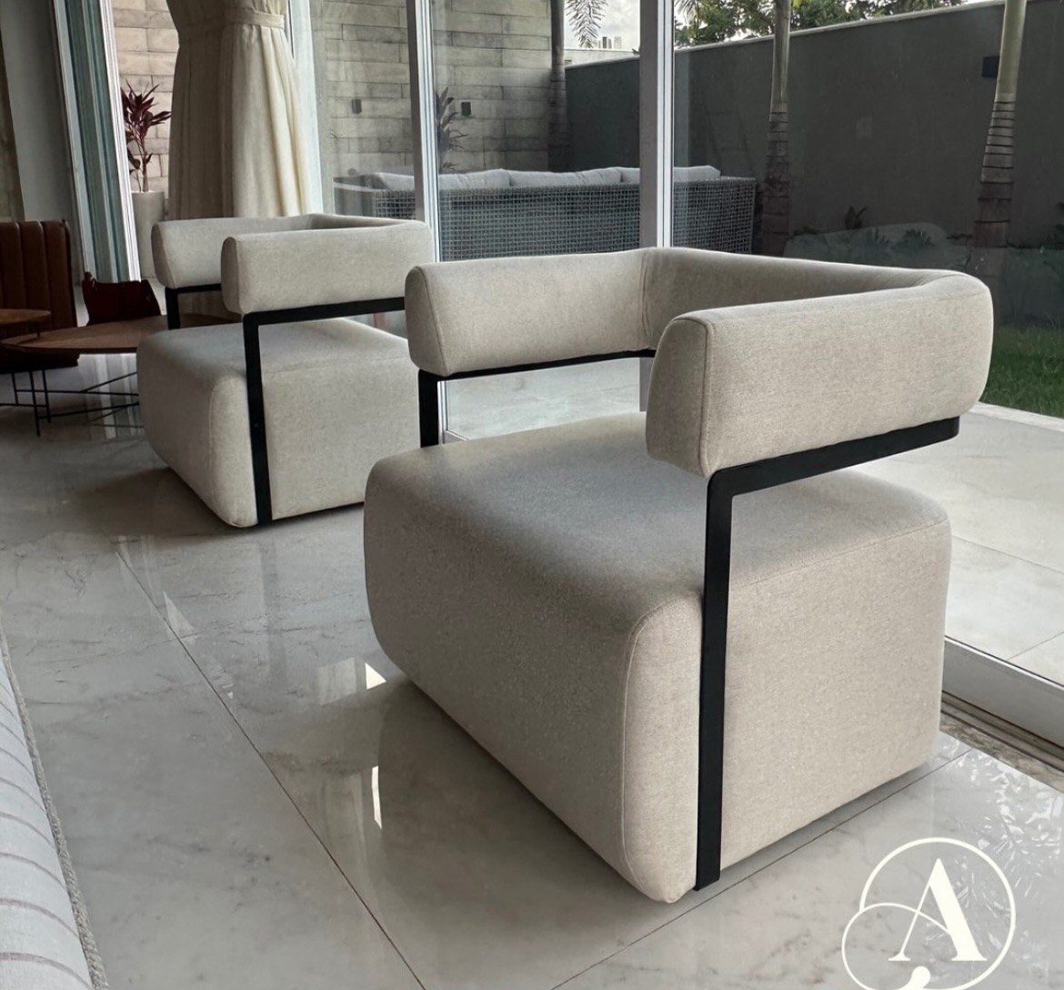 Poltronas off-white com estrutura metálica preta junto à varanda